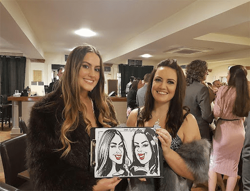 Wedding guests holding caricature drawings at reception party